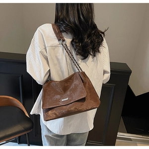 Détail du sac à bandoulière marron vintage avec cuir vieilli et bandoulière chaîne