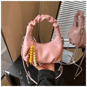 Pink crescent handbag with ruched handle, wood bead charm, and silver chain strap details