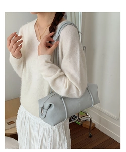 Detail of light blue cylinder shoulder bag with soft leather texture and zipper closure