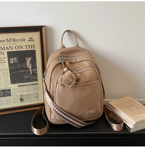 Detail of khaki leather backpack with litchi texture and embroidered shoulder straps