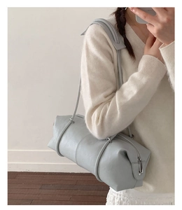 Detail view of light blue leather Boston bag showing silver zipper and slim shoulder strap