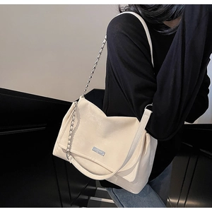 Détail du sac crème avec bandoulière en chaîne argentée et simili cuir mat élégant