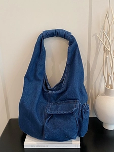 Vintage blue denim hobo shoulder bag with large front pocket and side drawstring detail