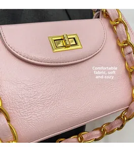 Detail of pink wrinkled faux leather bag with golden rectangle lock and chain strap