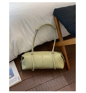 Detail of pistachio green leather bowling bag with vertical stitching and silver buckles