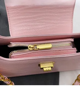 Detail of high-quality smooth golden zipper and pink pebble leather on chain bag