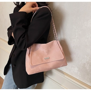 Détail du sac bandoulière en daim rose avec chaîne argentée et fermoir métallique
