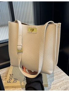 Grand sac fourre-tout minimaliste en cuir crème à texture litchi sur surface de marbre