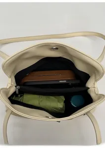 Vue intérieure du sac fourre-tout beige montrant plusieurs compartiments et sa capacité