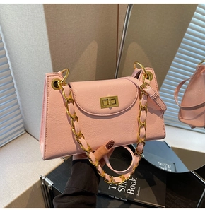 Détail du sac rose en cuir synthétique avec fermoir rotatif doré et bandoulière