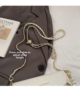 Detail of white textured leather bag with adjustable gold chain and pearl handle