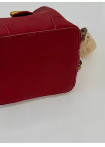 Detailansicht des verbreiterten Bodens und der roten Lederstruktur der Handtasche