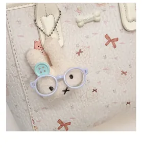 Gros plan d'un charme lapin avec lunettes sur un sac en cuir blanc à motif dessin animé