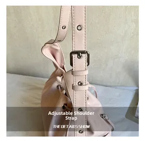 Detail of adjustable leather shoulder strap with silver buckle on pink tote bag