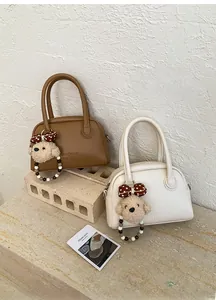 Detail of mini tote bags with lychee grain leather and plush dog charms
