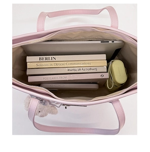 Interior detail of pink tote bag showing large capacity for laptop and books with silver zipper