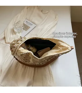 Spazioso interno della borsa in paglia beige con portafoglio e oggetti quotidiani