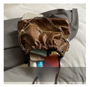 Detail showing spacious interior of quilted brown bag with tablet and cosmetics