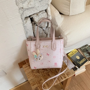 Détail du sac matelassé rose avec motifs de dessins animés et charm de lapin en peluche