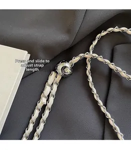 Detail of adjustable metal ball buckle on a white leather and silver chain strap