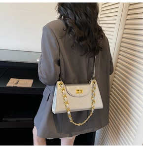 Détail du sac bandoulière argenté texturé avec boucle dorée et bandoulière en chaîne