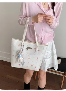 Detail of cream tote bag with bear charm and cute bow patterns for daily casual use