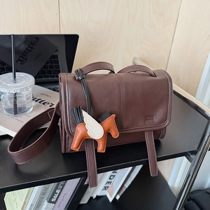 Brown vintage leather crossbody bag featuring a decorative Pegasus horse charm detail
