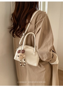 Stijlvolle beige crossbodytas met pluche beer en parels getoond op een model