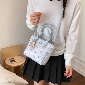 Détail du sac à main à motif de dessin animé bleu et blanc avec un lapin en peluche
