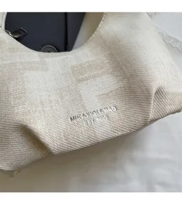 Close-up of beige woven texture featuring F-letter jacquard and silver brand logo