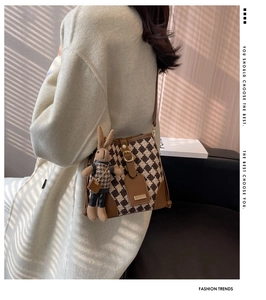 Detail of retro bucket bag with rhombus pattern knit and cute plush rabbit charm