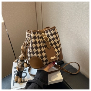 Close-up of houndstock weaving and leather drawstring detail on a brown bucket bag