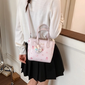 Détail du sac cabas rose avec motifs cartoon et pendentif lapin en peluche