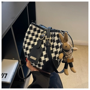 Detail of houndstooth bucket bag with leather trim and a cute bunny bag charm