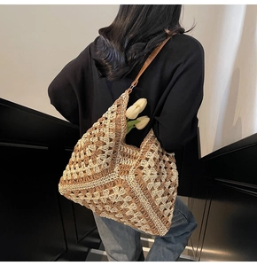 Dettaglio della borsa hobo intrecciata con motivo a uncinetto e tracolla in pelle marrone