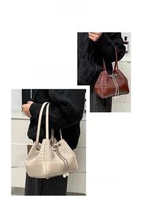 Detail der gewebten Beuteltasche mit Perlenkette und Kordelzug auf schwarzem Pullover