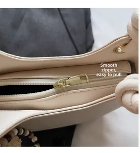 Detail showing smooth gold metal zipper and lychee grain leather texture of bucket bag