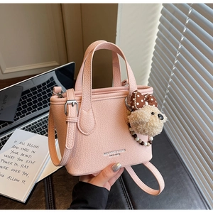 Pink lychee grain leather bucket bag with cute bear charm and silver hardware detail