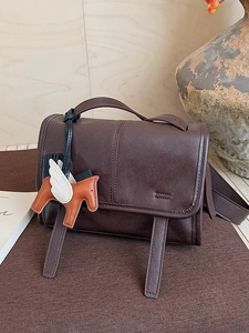 Retro dark brown crossbody bag with decorative straps and a flying horse charm