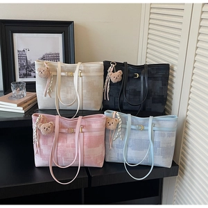 Detalle de cuatro bolsos tote vintage con tela texturizada y colgantes de oso de peluche