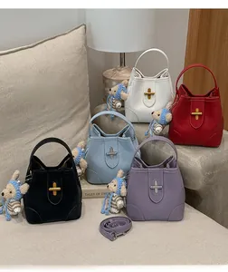 Macro shot of stylish leather bucket bags in five colors with metal clasp and bear charm