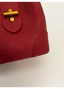 Close-up of red lychee grain leather bucket bag with premium gold rotary metal lock