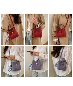 Detail of lychee pattern leather bucket bag with twist lock and bear charm accessory