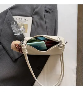 Spacious interior of a cream leather dumpling bag showing phone and power bank storage