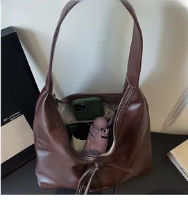 Spacious interior of retro brown leather tote bag showing umbrella and phone storage