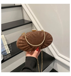 Detail of brown pleated evening clutch with gold metal frame and crystal clasp buckle
