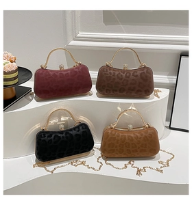 Détail de quatre pochettes léopard avec poignées dorées et fermoirs en diamant