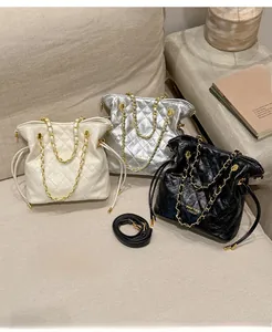 Detailed close-up of quilted chain bucket bags in beige, silver, and black colors