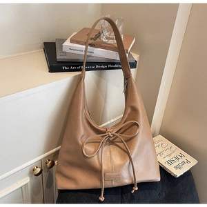 Macro view of brown vintage hobo bag with delicate bow tie and logo detail
