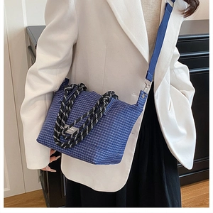 Detail of blue plaid tote bag featuring woven rope handles and adjustable nylon strap